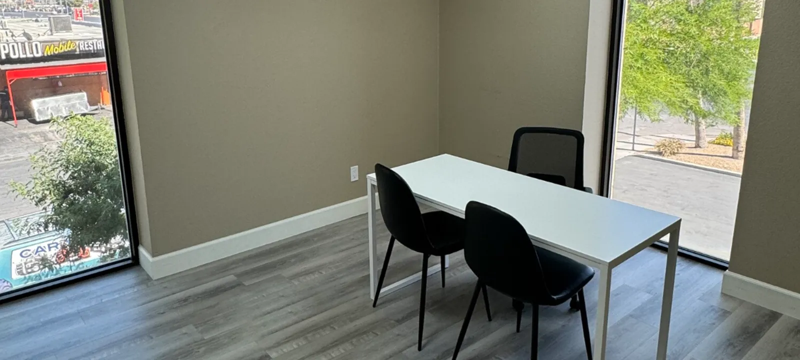 Private office at The Office Business Center with a desk, chairs and natural light